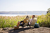 Couple sunbathing on lounge chairs