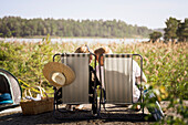 Couple sunbathing on lounge chairs