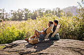 Couple sunbathing on lounge chairs