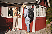 Junge Männer stehen vor einem Holzhaus