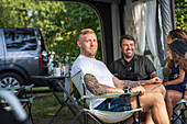 Mann entspannt sich auf einem Campingplatz