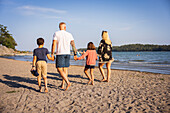 Familie beim gemeinsamen Spaziergang am Strand