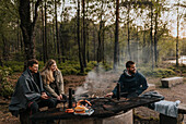 Friends having grill in forest