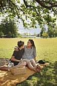 Mutter mit Sohn auf Picknickdecke sitzend