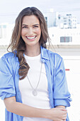 A young woman wearing a white t-shirt and a blue long blouse