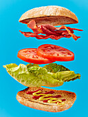 Schwebendes Sandwich vor blauem Hintergrund