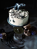 Mascarpone cake with a black spider’s web and a plastic rat