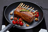 Pan fried rack of lamb with cherry tomatoes and garlic