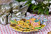 Sugar cookies with assorted sprinkles on a plate with Christmas decorations