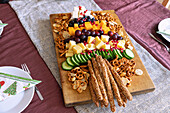 Christmas tree-shaped snack platter with cheese, fruit, pretzels and crackers