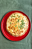 A savoury pancake made with egg batter and seasoned with spring onions and toasted sesame oil