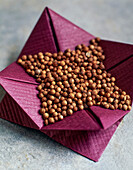 Coriander seeds in origami paper bowls
