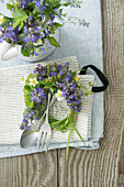 Wreath of Bugleweed and strawberry leaves and flowers, on a napkin and cutlery