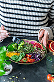 Frau isst Salad Bowl mit Quinoa