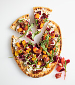 Flat bread topped with red and yellow beets, bacon, goat cheese and rocket