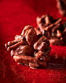 Chocolate candy crispies on a red background (Close Up)