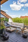 Outdoor-Sitzmöbel und Bodenlaternen auf Dachterrasse