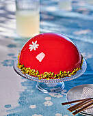 Mousse cake with red mirror glaze and pistachios