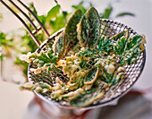 Herb tempura on sieve spoon