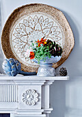 Fireplace detail with hessian tray and pewter vase with flowers