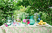 Sammlung von Glasvasen und Krügen auf einem Gartentisch