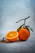 Orange halbiert und ganz mit Blättern