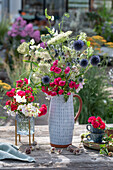 Summer bouquet with roses, globe thistles, greater burnet saxifrage, poppy pods, and sweet peas