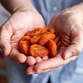 Hands holding dried apricots