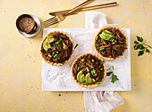 Warm glass noodle salad with beech mushrooms, soy, and avocado in shortbread bowls, vegan