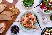 Parma ham with melon, pimientos de padrón, and salad with mozzarella balls