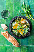 Baked eggs with wild garlic and herbs