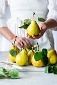Woman presents pears with leaves
