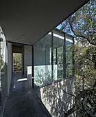 Hallway with glass walls in concrete house