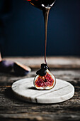 Chocolate sauce drizzling over a fresh fig half
