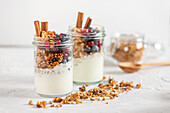 Granola in jars with yogurt, fruits and spices