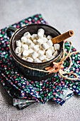 Mini marshmallows with a cinnamon stick in ceramic bowls