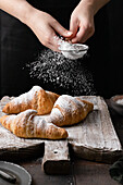 Dusting croissants with powdered sugar