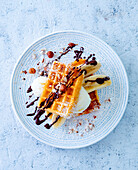 Belgian waffles with bananas, ice cream, hazelnuts, and chocolate sauce