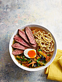Asian beef ramen noodle bowl with egg