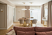 View over sofa to dining area in elegant living room in pastel shades