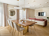 Dining area, sofa, and television in an elegant living room in pastel shades