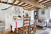 Bright dining room with gnarled ceiling beams, country-style chairs