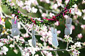 Homemade Easter bunny garland hanging from a blossoming fruit tree