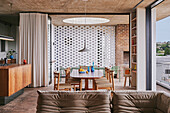 View from the seating area to the kitchen and dining table in front of decorative concrete wall