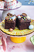 Easter chocolate cake squares on a yellow pedestal dish