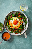 Fried eggs with turmeric on kale salad