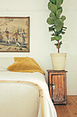 Double bed, with vintage bedside cabinet with houseplant
