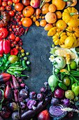 Fruit and vegetables in rainbow colors creating a picture border with copy space
