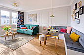 Corner bench with grey upholstery in the dining area, green velvet sofa, and coffee tables in the background