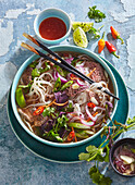 Asian beef soup with rice noodles and chilies